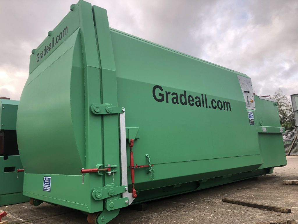 Side view of the Gradeall GPC P24, a portable wet waste compactor, showcasing its hook lift mechanism for easy transport
