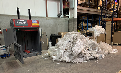 Large pile of plastic waste beside Gradeall G eco 150 Baler 1