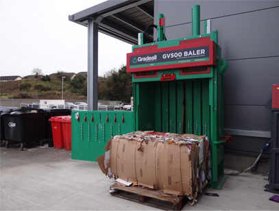 Gradeall GV-500 baler with ejected cardboard bale in front.