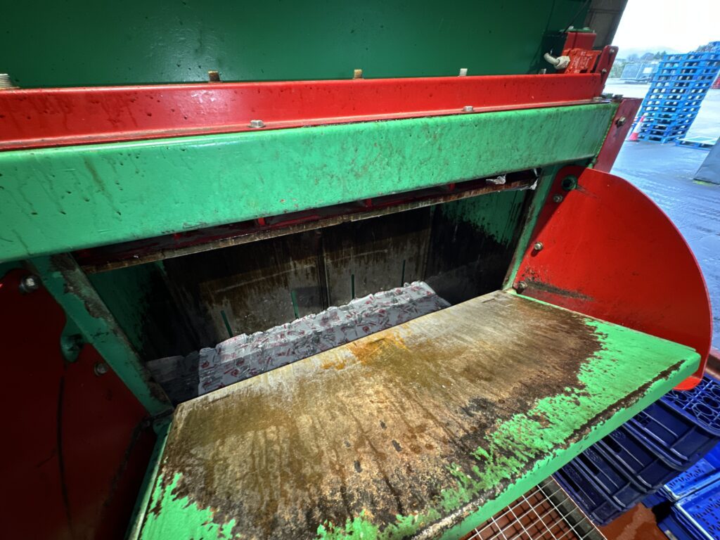 Inside view of the Gradeall Can Baler showing crushed aluminium cans ready for baling.