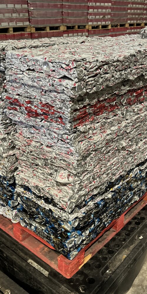 Stacked bales of scrap aluminium cans, compressed by a drink can crusher machine.