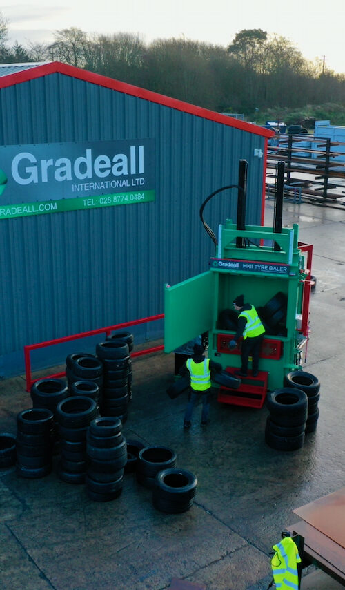 Workers test a Gradeall MK2 tyre baler on a winter morning at the Gradeall factory.