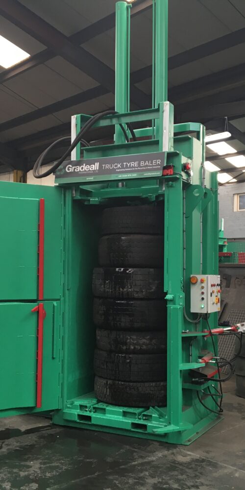 Industrial Gradeall Truck Tire Baler machine compressing used truck tires.