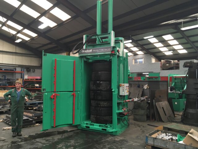 Industrial Gradeall Truck Tire Baler machine compressing used truck tires.