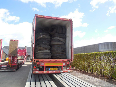 A shipping container filled to the brim with Gradeall Truck Tyre Bales.