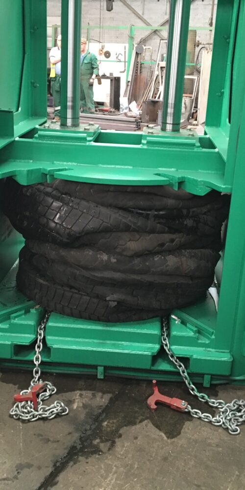 Completed bale of tyres in the Gradeall Truck Tyre Baler with chain-based ejection system.