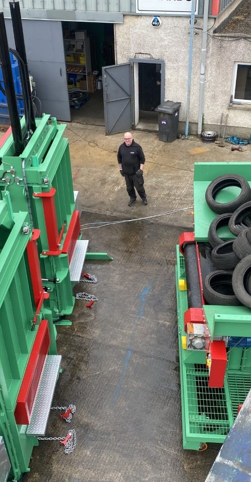 Overhead view of a Gradeall inclined tyre baler conveyor system in an industrial yard, highlighting the comprehensive setup for tyre recycling.